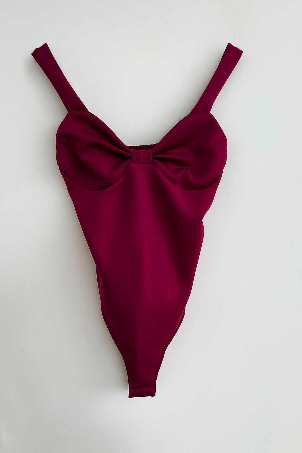 body de mujer de tirantes color buganvilla y escote en V con cazuelas y detalle de nudo en el pecho. Tela neopreno elástica.